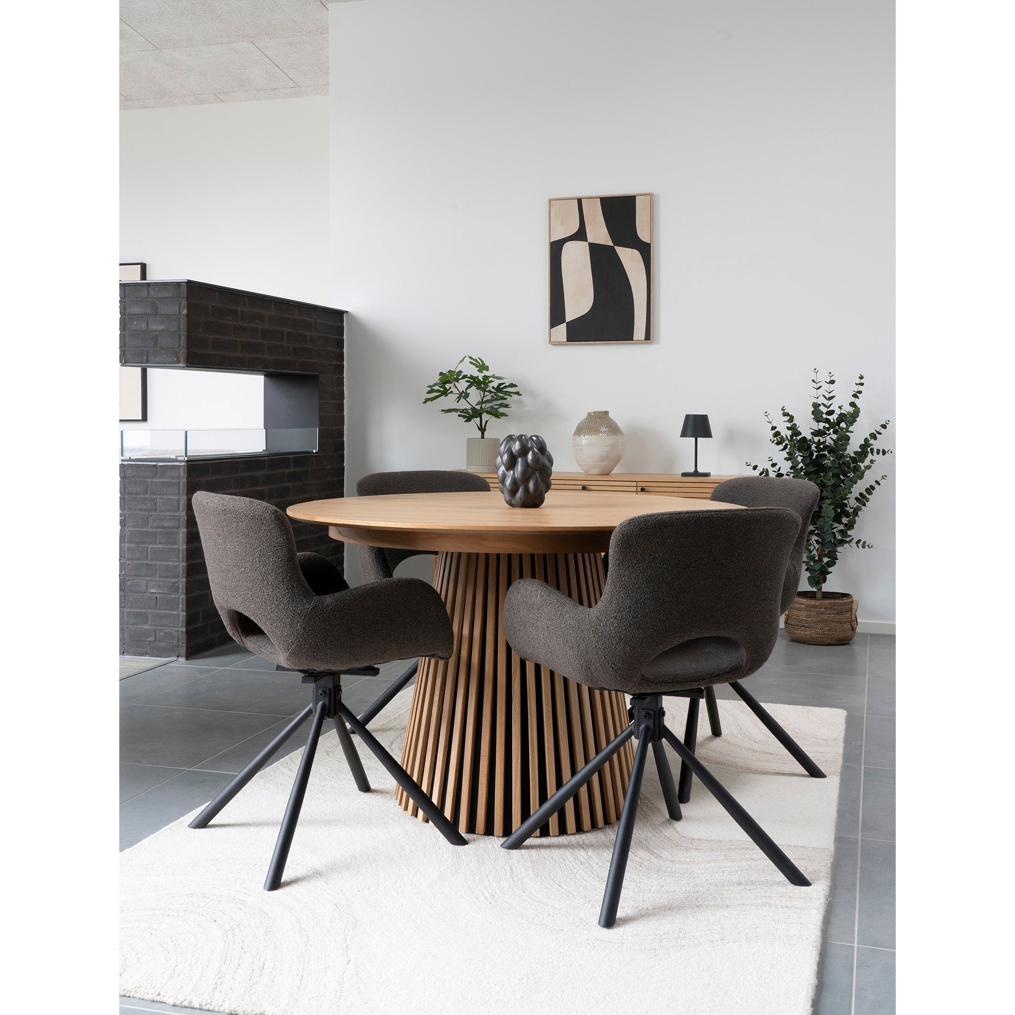 Chaises Amorim pivotantes bouclé mushroom autour table ronde bois cannelée avec cheminée et tableau graphique