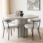 Quatre chaises Badalona bouclé blanc autour d'une table ronde grise dans salle à manger scandinave épurée