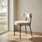 Chaise de salle à manger Badalona bouclé blanc assise ronde rembourrée pieds acier noir en situation