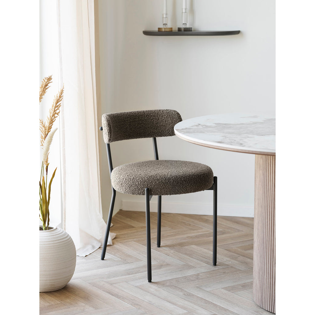 Chaise Badalona bouclé marron devant une table ronde marbre dans salle à manger épurée lumineuse