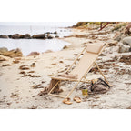 Chaise de plage Curtis taupe sur le sable au bord de la mer avec serviette et sac