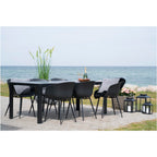 Chaises Roda noires avec coussins gris et peau lainée autour d'une table noire en bord de mer