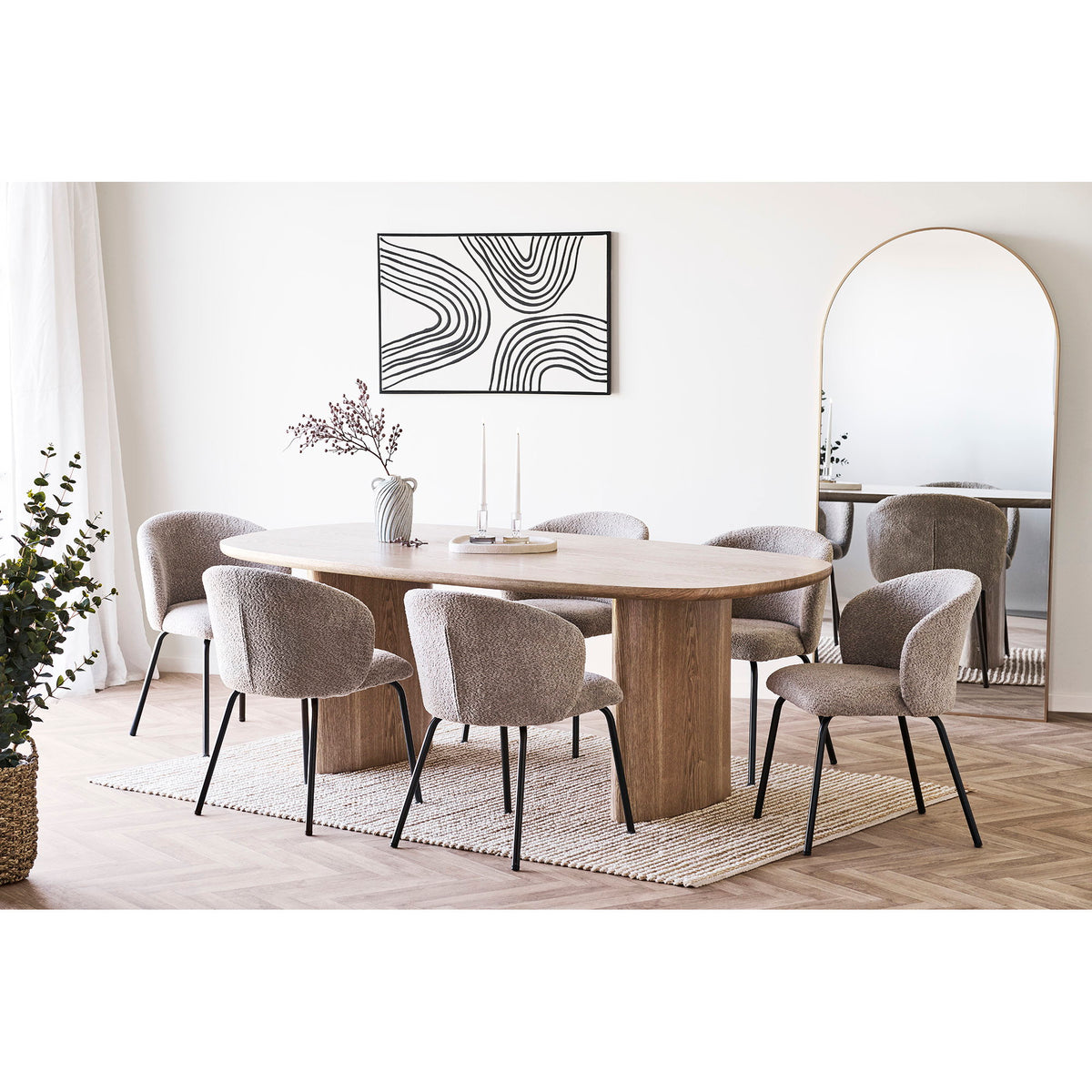 Six chaises Safira bouclé beige autour d'une table ovale en bois clair sur un tapis tressé