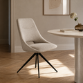 Chaise de salle à manger pivotante Dokka en tissu chiné sable à piètement étoile noir, près d'une table ronde dans un intérieur lumineux