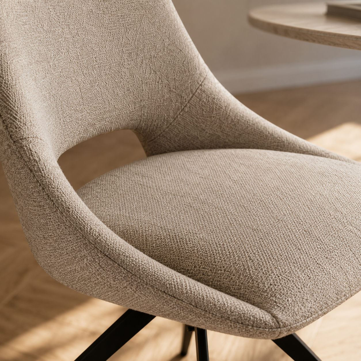 Gros plan sur l'assise et la découpe ouverte signature de la chaise Dokka en tissu chiné sable naturel