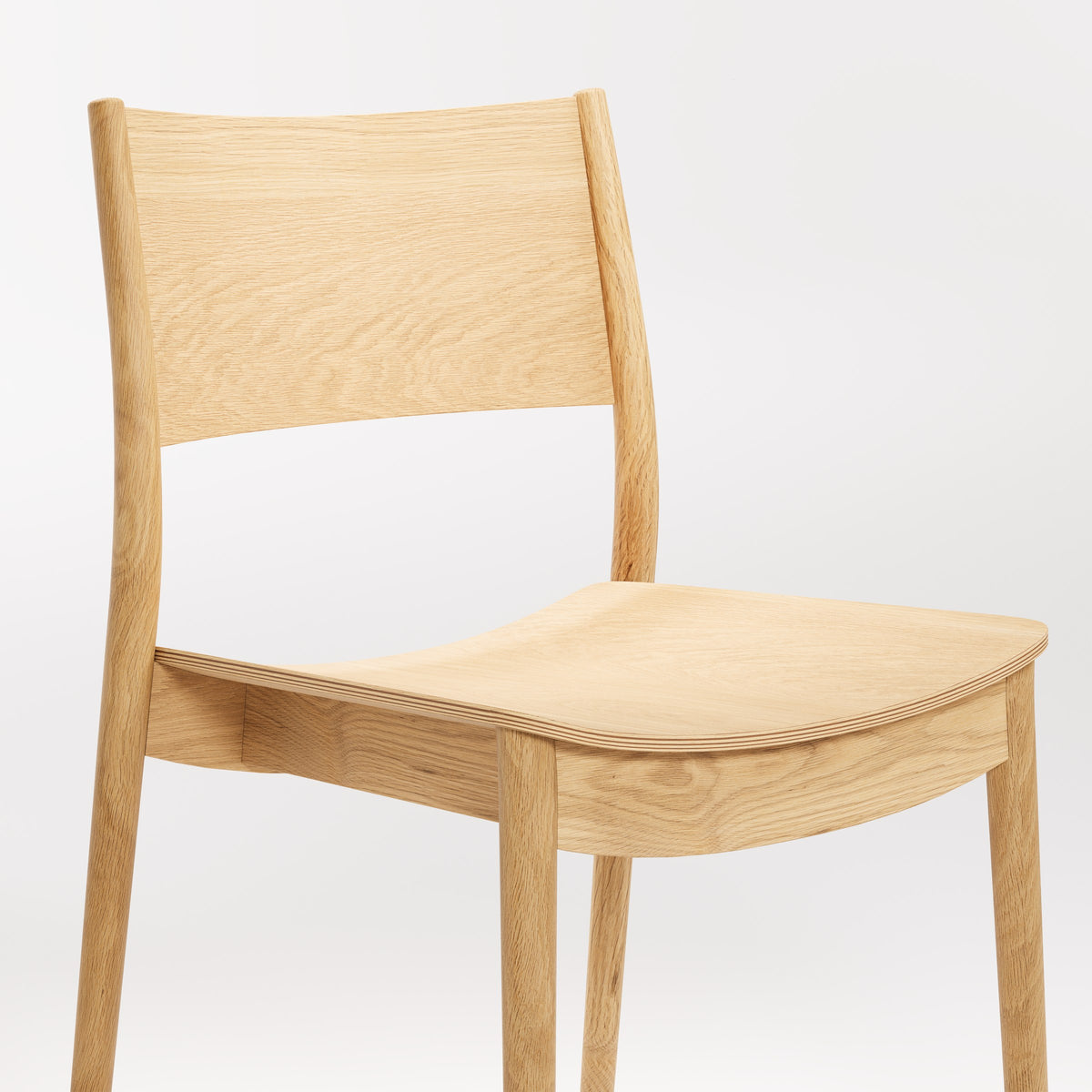 Détail de l'assise de la chaise empilable Vio en chêne naturel