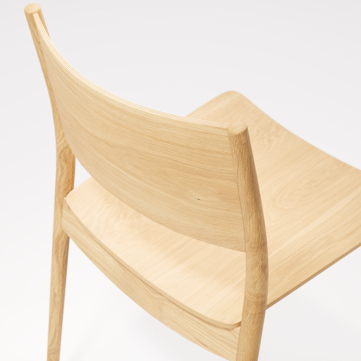 Détail du dossier de la chaise empilable Vio en chêne naturel