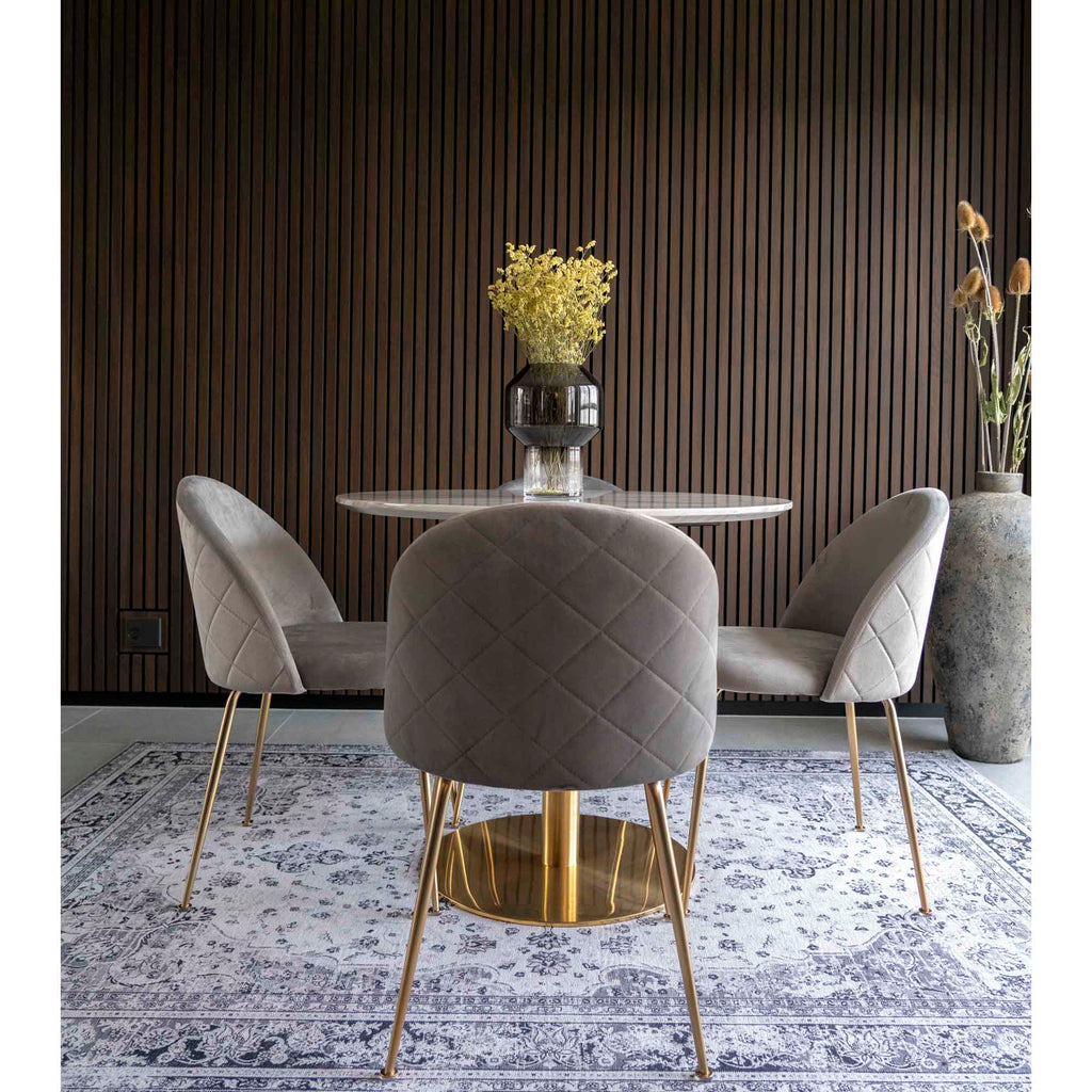 Trois chaises Geneve velours gris autour d'une table ronde marbre et laiton fond lambris sombre