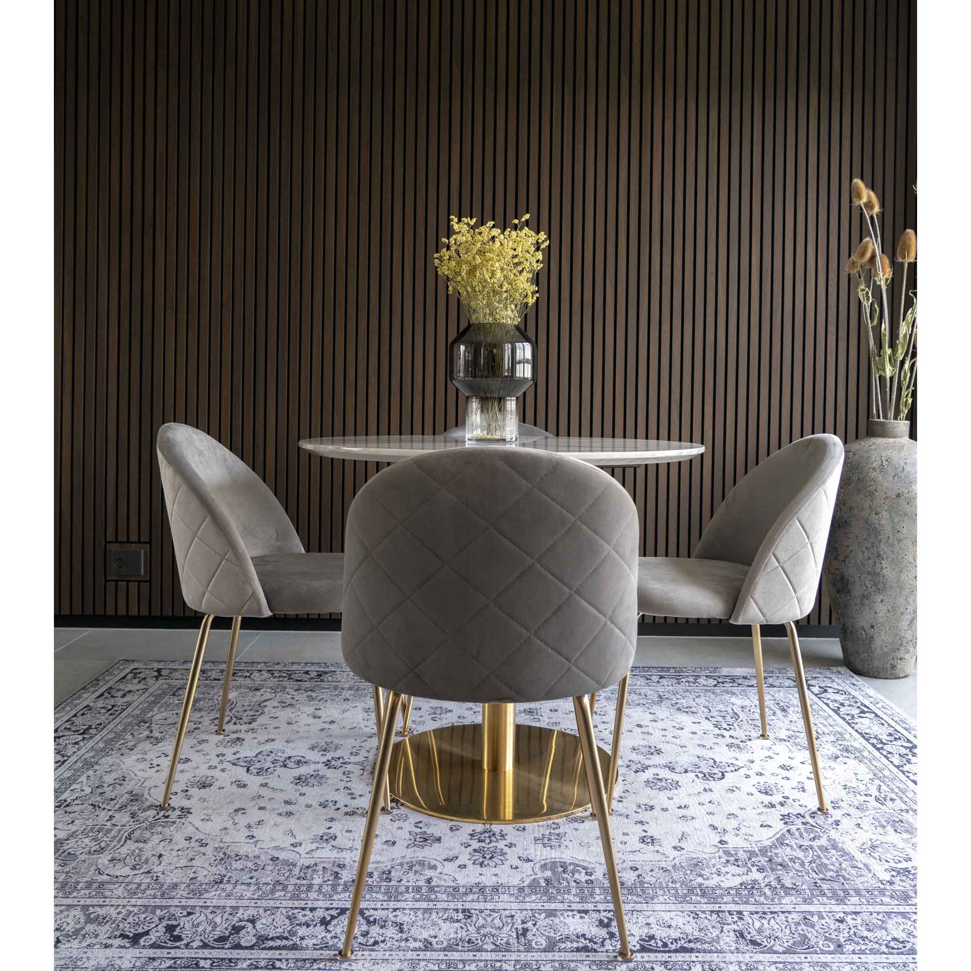 Trois chaises Geneve velours gris autour d'une table ronde marbre et laiton fond lambris sombre