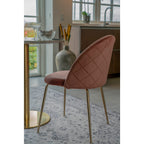 Deux chaises Geneve velours rose autour d'une table ronde marbre laiton dans salle à manger lumineuse