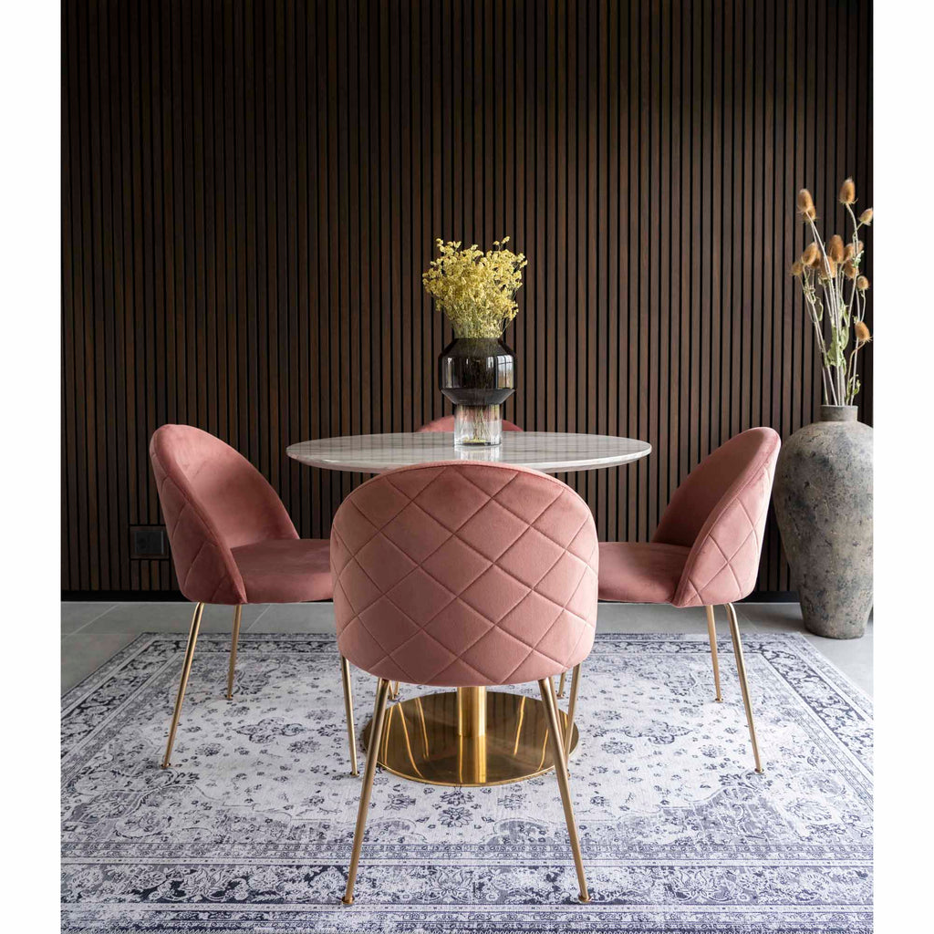 Trois chaises Geneve velours rose autour d'une table ronde marbre et laiton fond lambris sombre