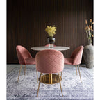Trois chaises Geneve velours rose autour d'une table ronde marbre et laiton fond lambris sombre