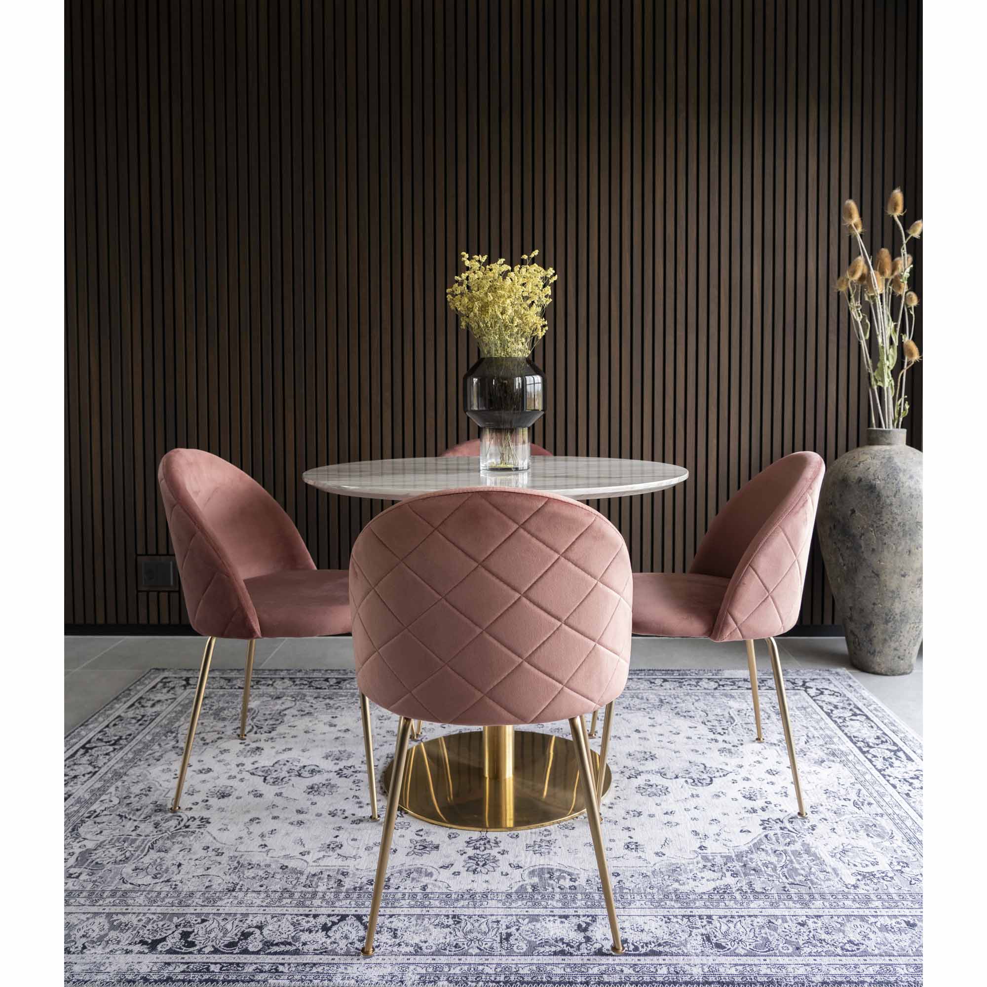 Trois chaises Geneve velours rose autour d'une table ronde marbre et laiton fond lambris sombre