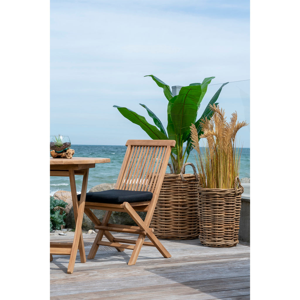 Chaise Toledo teck avec coussin noir sur terrasse en bois bord de mer vue rapprochée