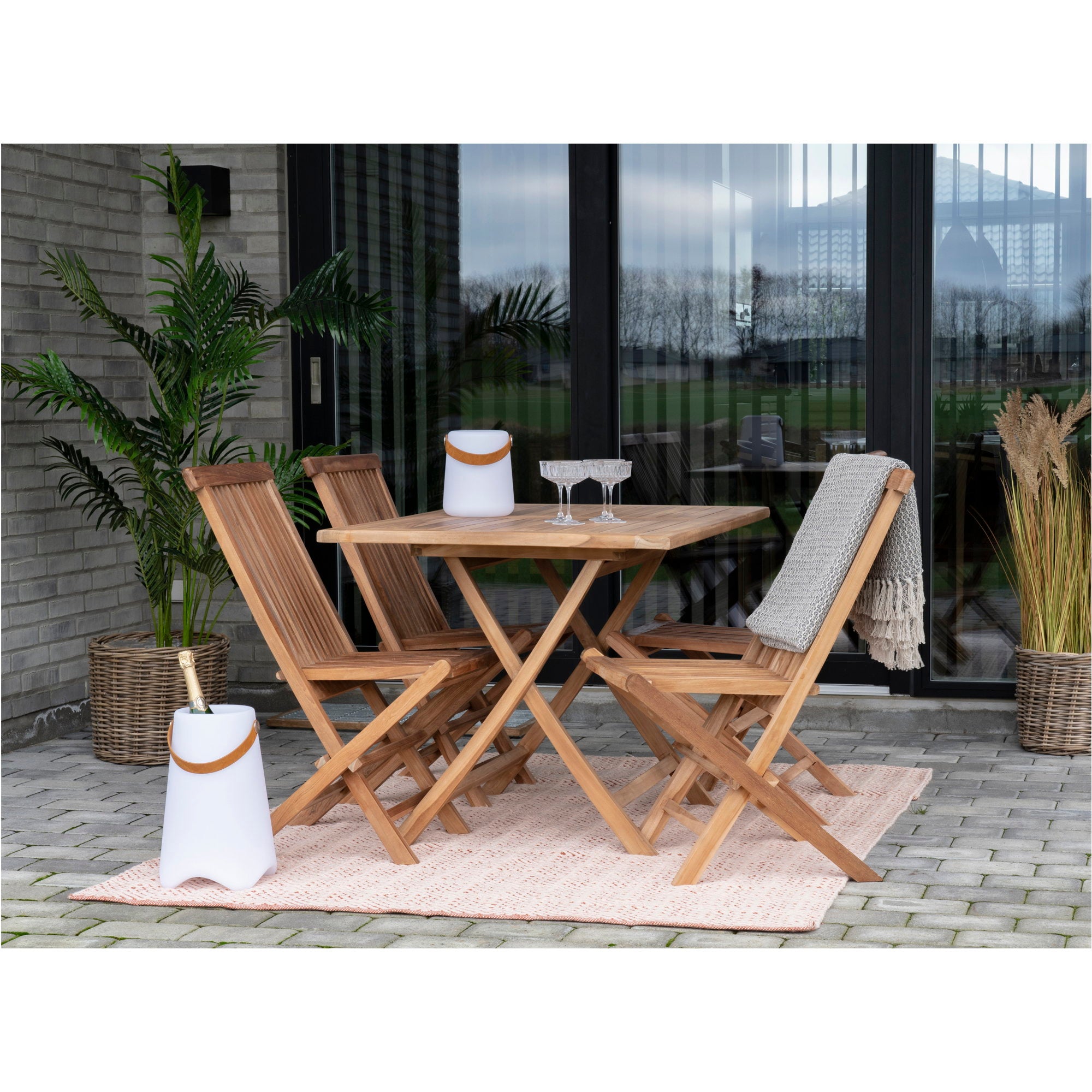 Quatre chaises Toledo teck autour table carrée teck sur terrasse avec seau champagne