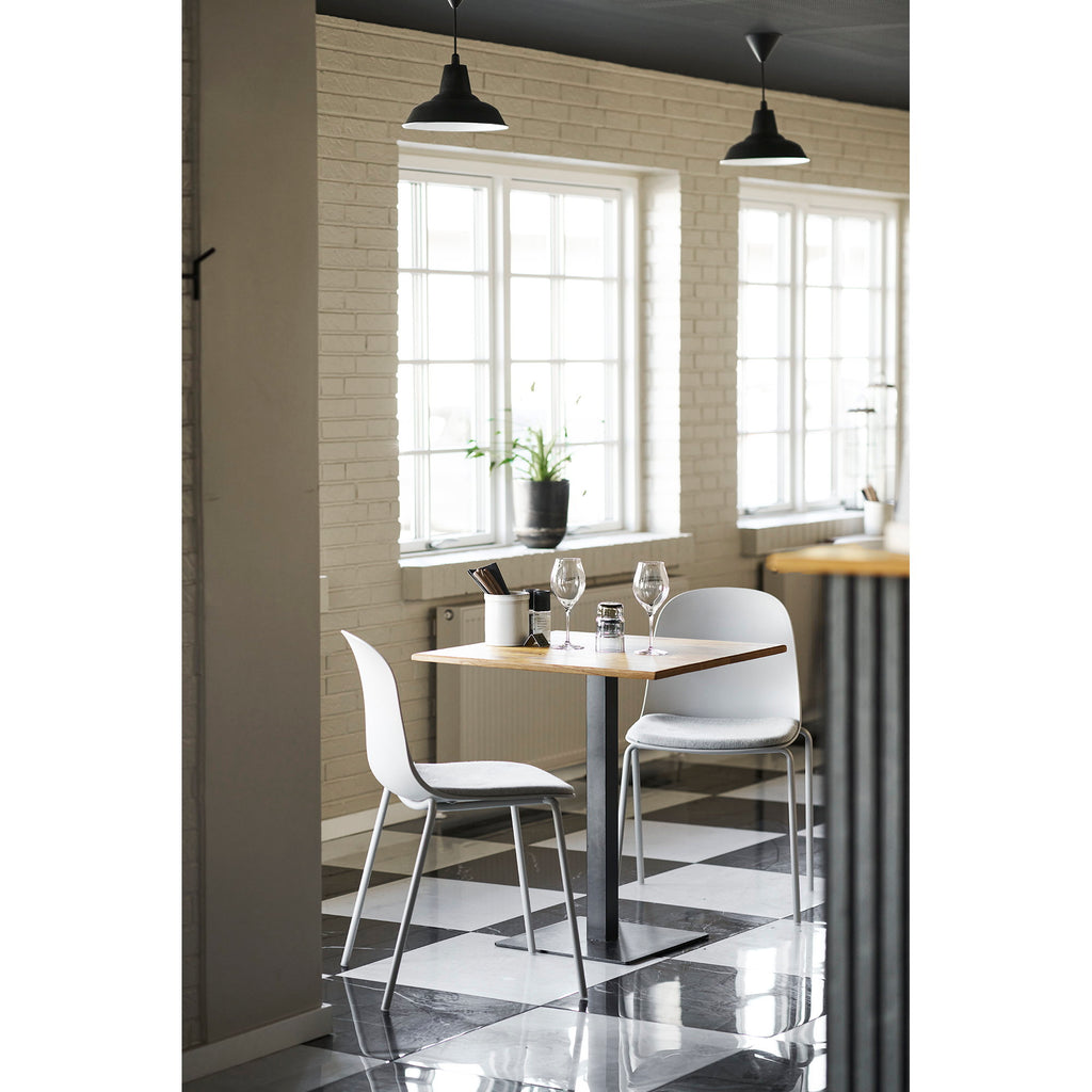 Deux chaises Madalena gris clair autour d'une table bistrot dans espace restaurant contemporain