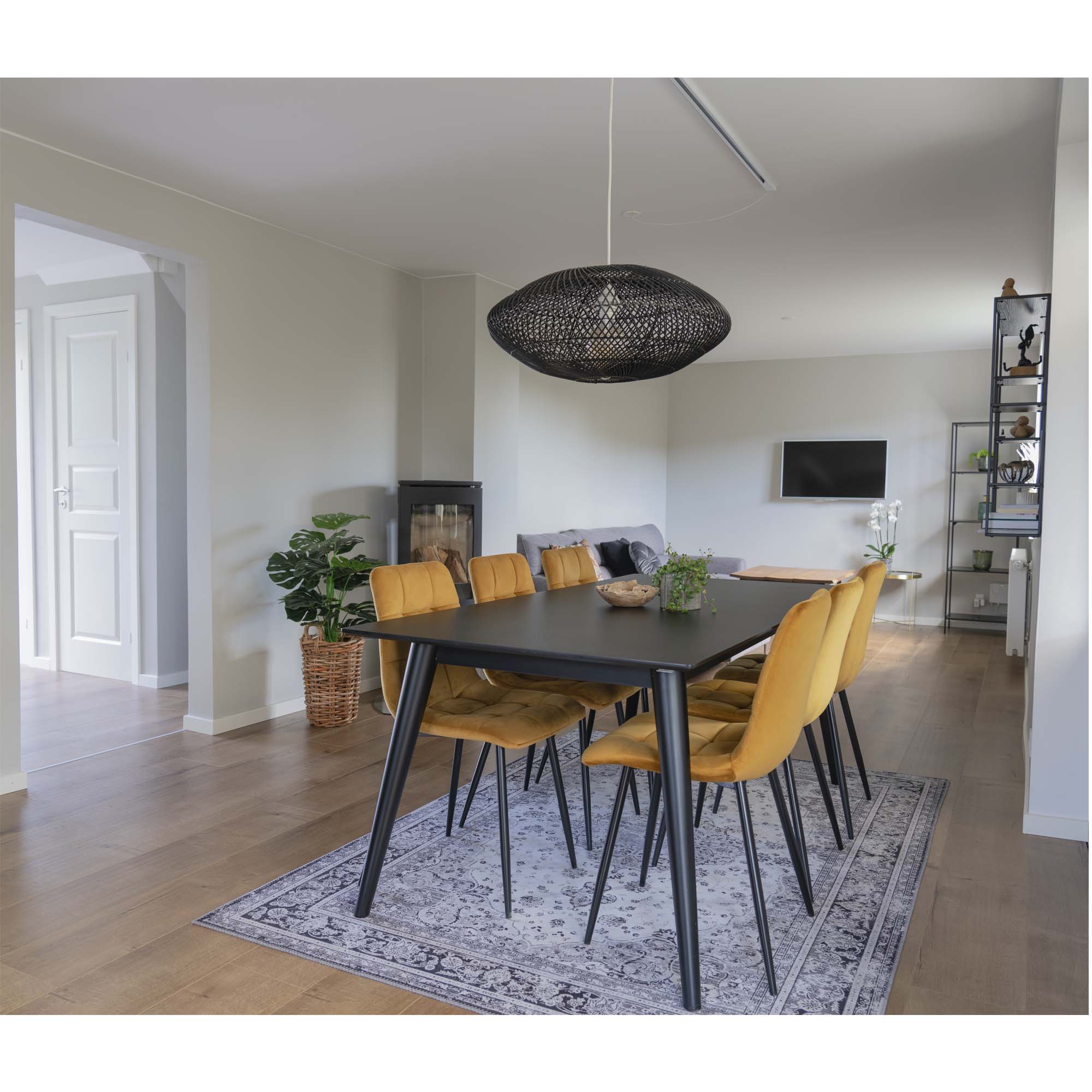 Chaises Middelfart jaune moutarde autour d'une table noire vue d'ensemble salon contemporain