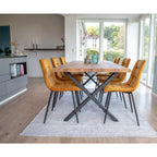 Chaises Middelfart velours jaune moutarde autour d'une table en bois massif pieds croisés noirs