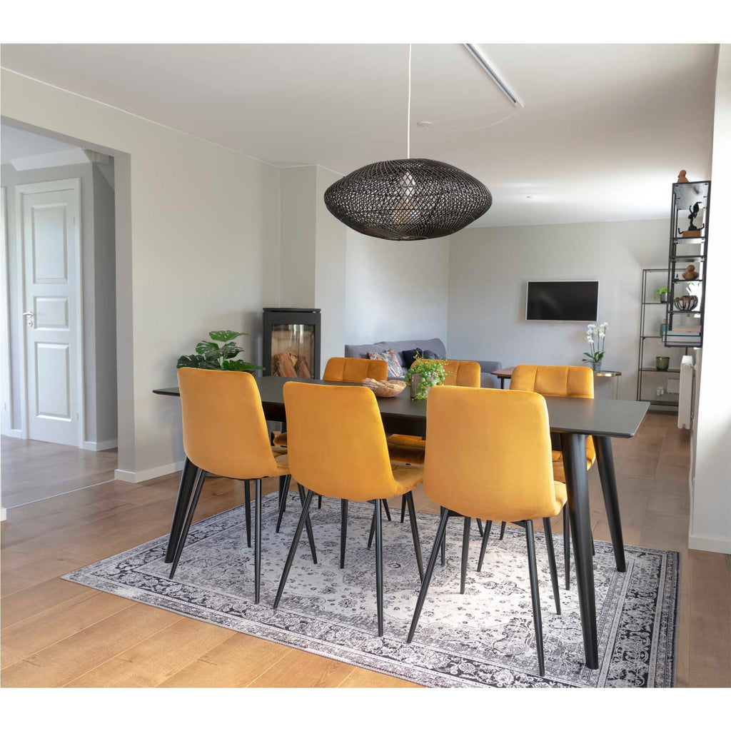 Lot de chaises Middelfart jaune moutarde autour d'une table noire dans salle à manger moderne