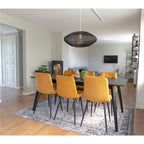 Lot de chaises Middelfart jaune moutarde autour d'une table noire dans salle à manger moderne