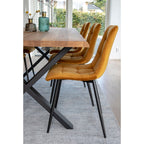 Détail du matelassage et profil des chaises Middelfart jaune moutarde le long d'une table bois