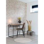 Chaise Middelfart microfibre brun clair utilisée comme siège de bureau avec console bois mur briques bougie et pampa
