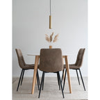 Chaises Middelfart microfibre brun clair autour table ronde blanche pieds bois suspension dorée pampa