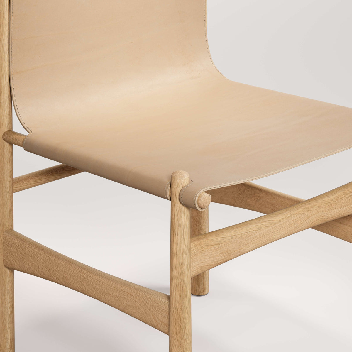 Détail de l'assise de la chaise Nook en chêne et cuir naturel