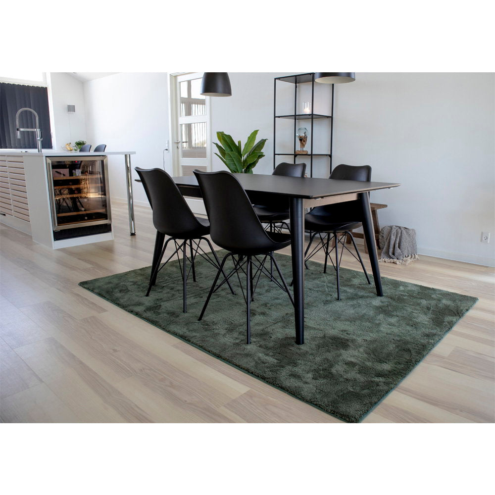 Lot de 2 chaises Oslo noires autour d'une table salle à manger sur tapis vert – ambiance nordique