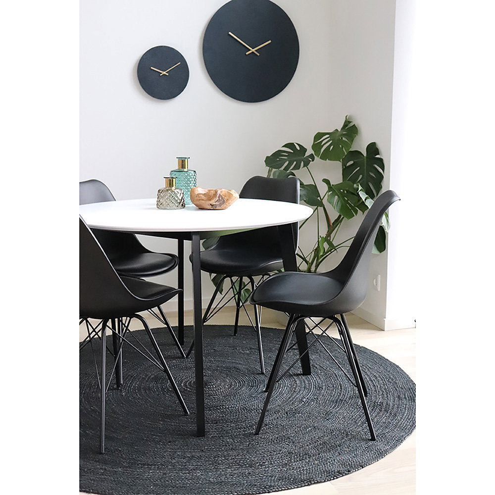 Chaises Oslo noires autour d'une table ronde blanche – décoration nordique minimaliste