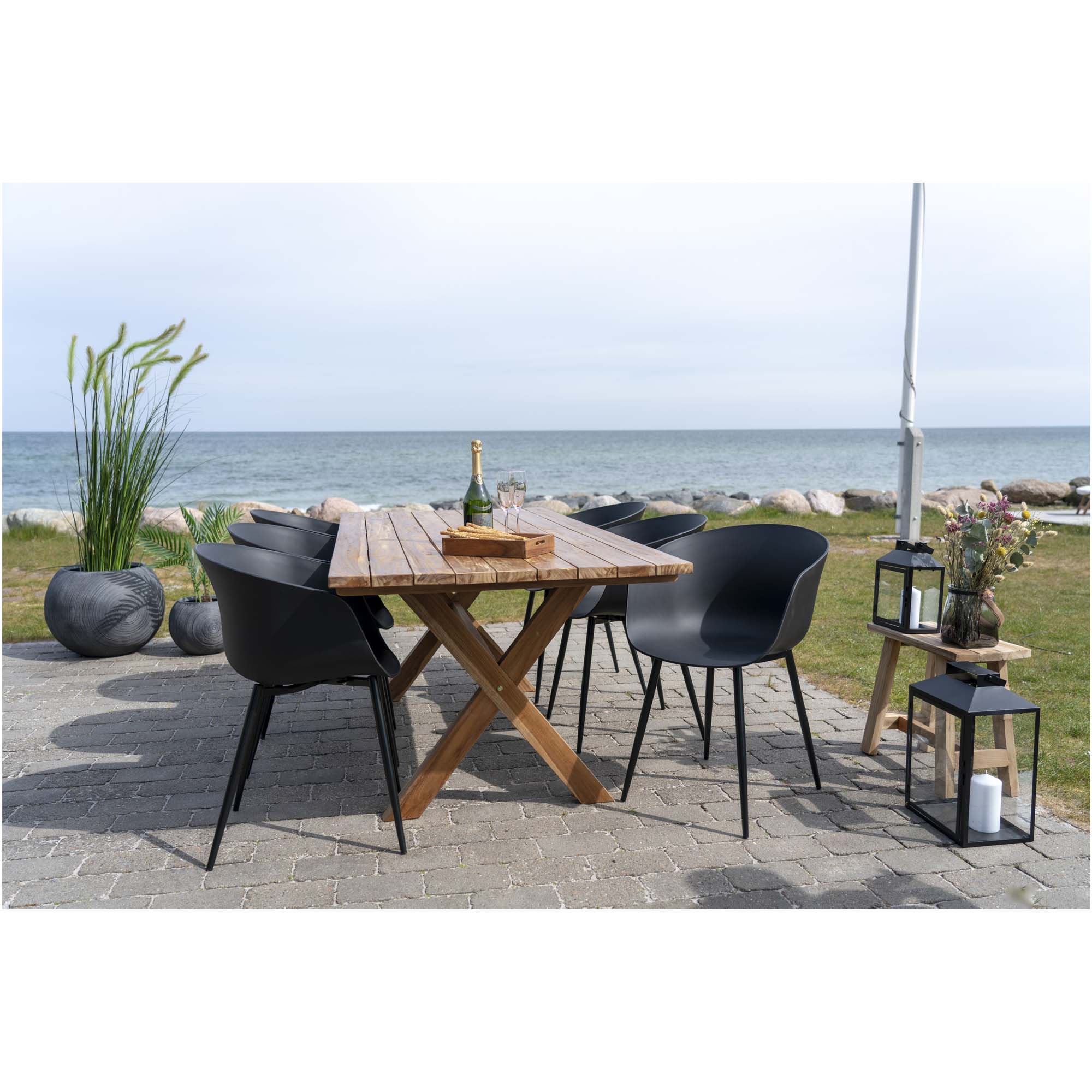 Lot de chaises Roda noires autour d'une table en teck terrasse bord de mer