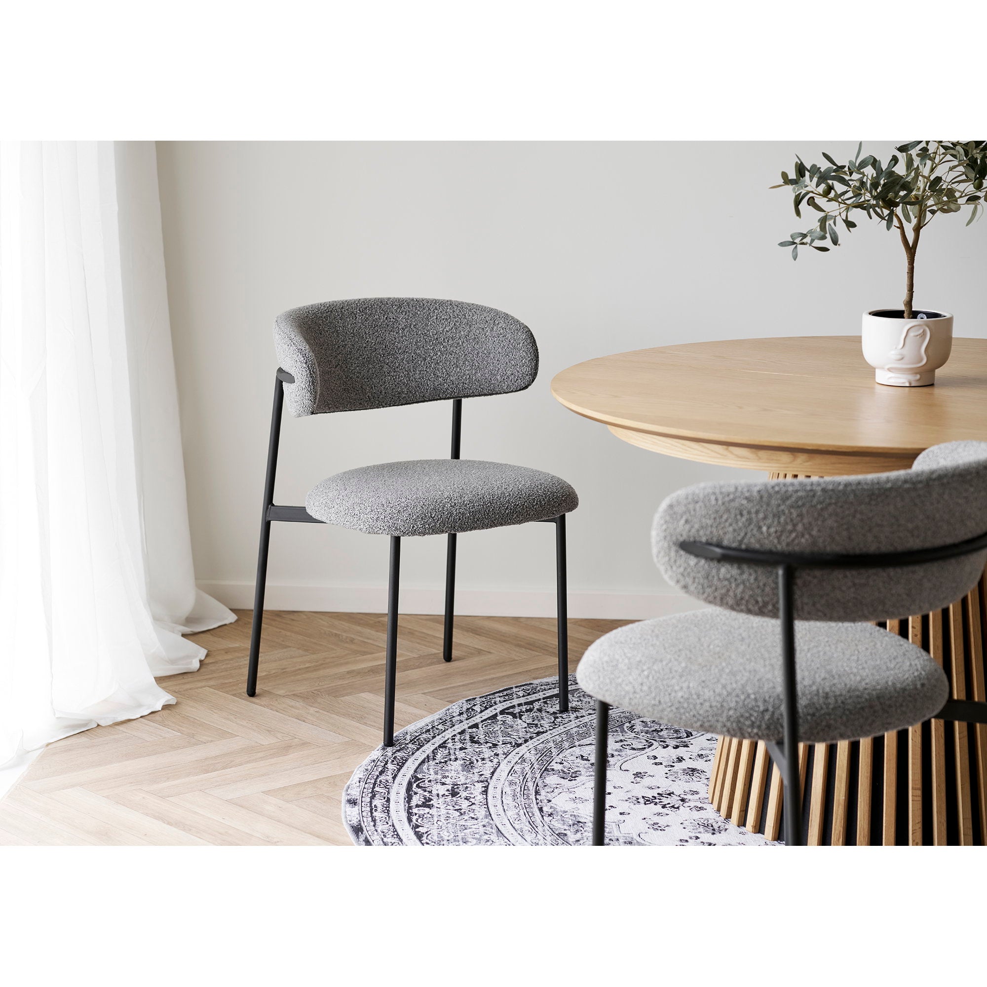 Chaises de salle à manger Mira bouclé gris clair dossier flottant autour d'une table ronde en chêne naturel