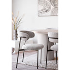 Chaises Mira bouclé sable autour d'une table ovale cannelée blanche salon lumineux contemporain