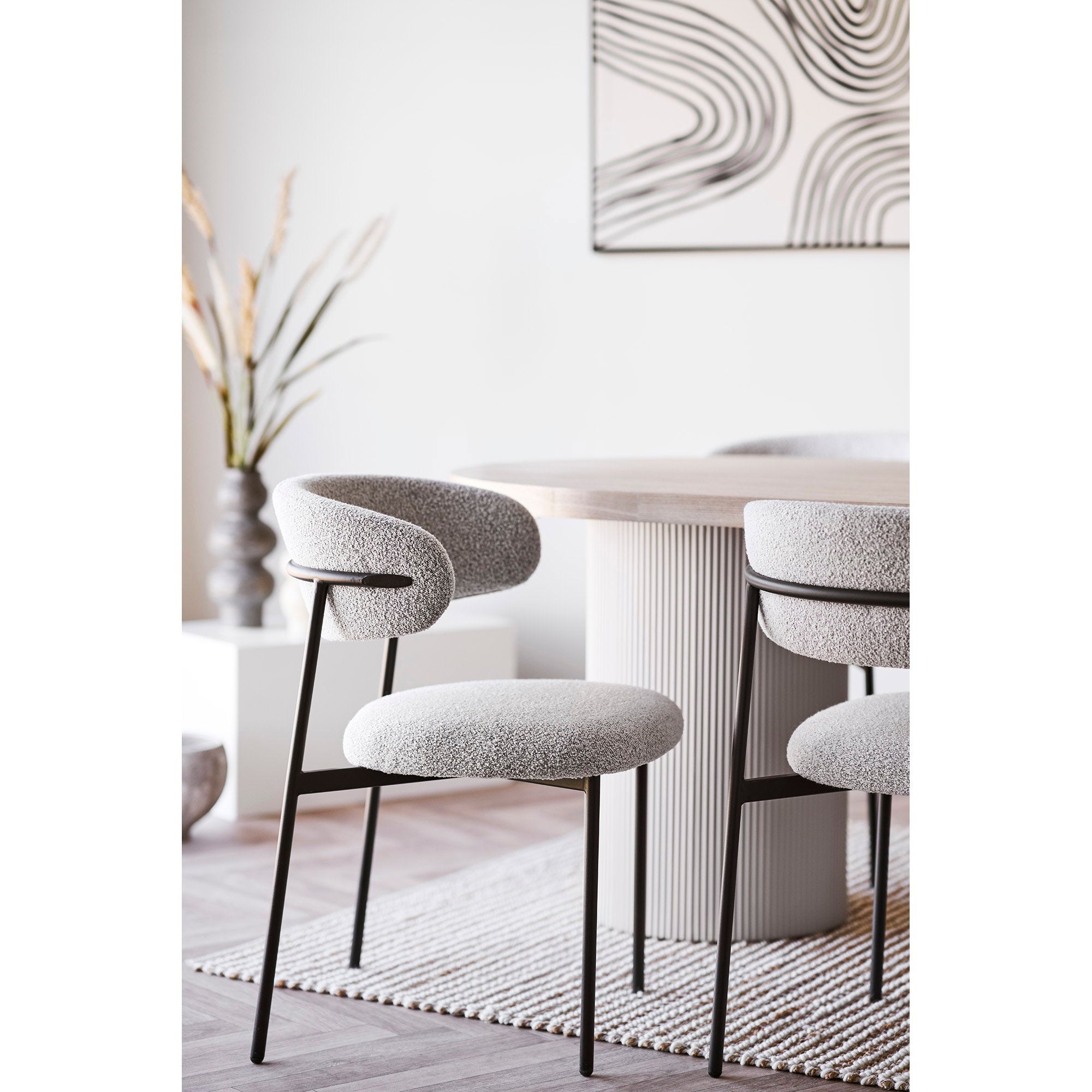Chaises Mira bouclé sable autour d'une table ovale cannelée blanche salon lumineux contemporain