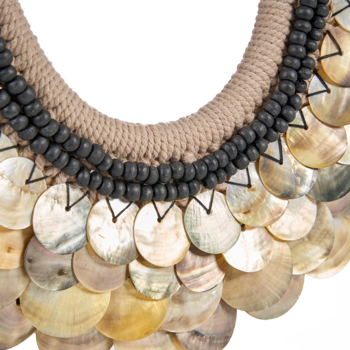 Gros plan sur les disques de nacre tenus au fil noir sous le double rang de perles du collier Clam Couture