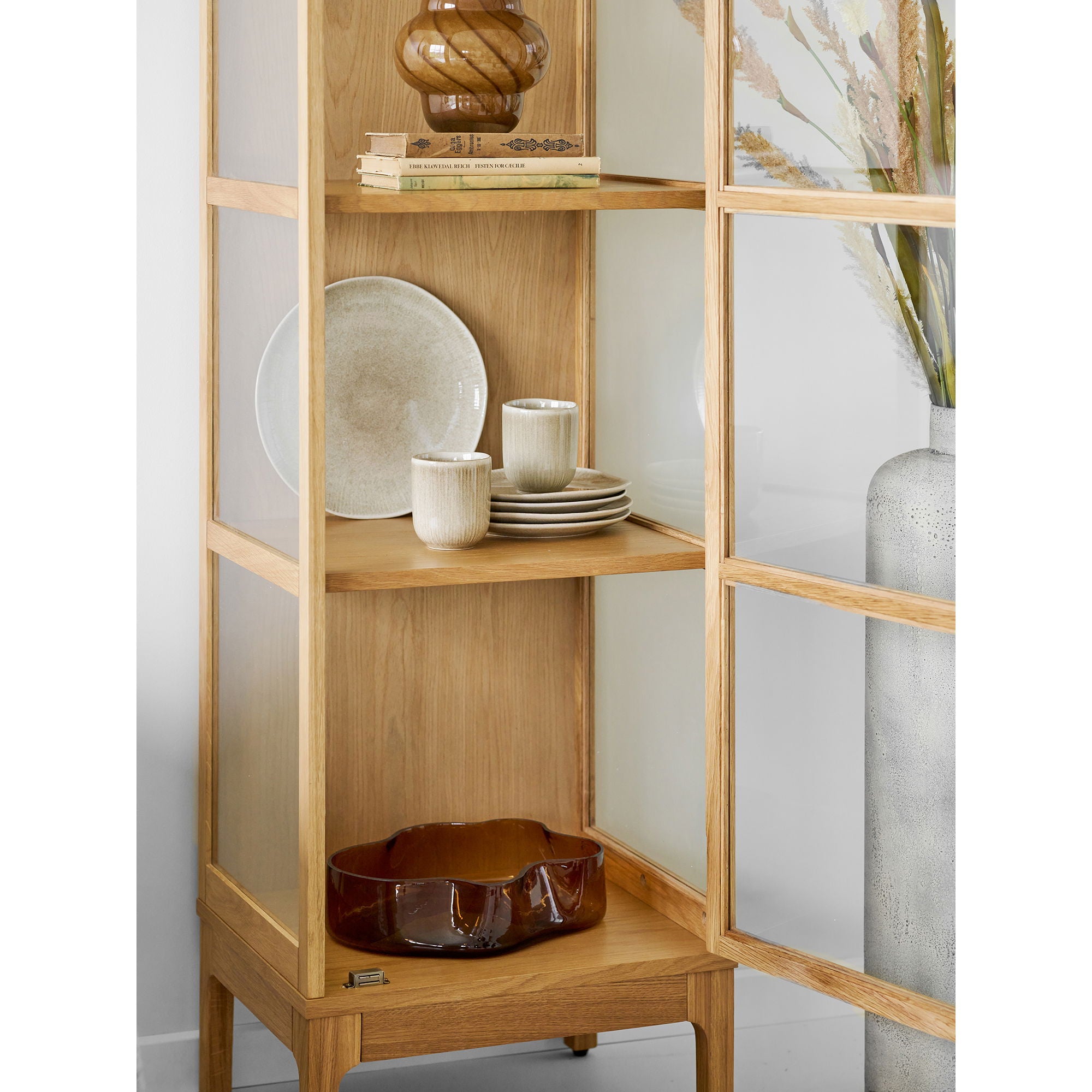 Coupe verre soufflé brun ambré posée dans meuble vitrine bois chêne naturel décoration
