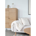 Coussin Albany blanc tufté sur canapé gris salon scandinave armoire bois chêne