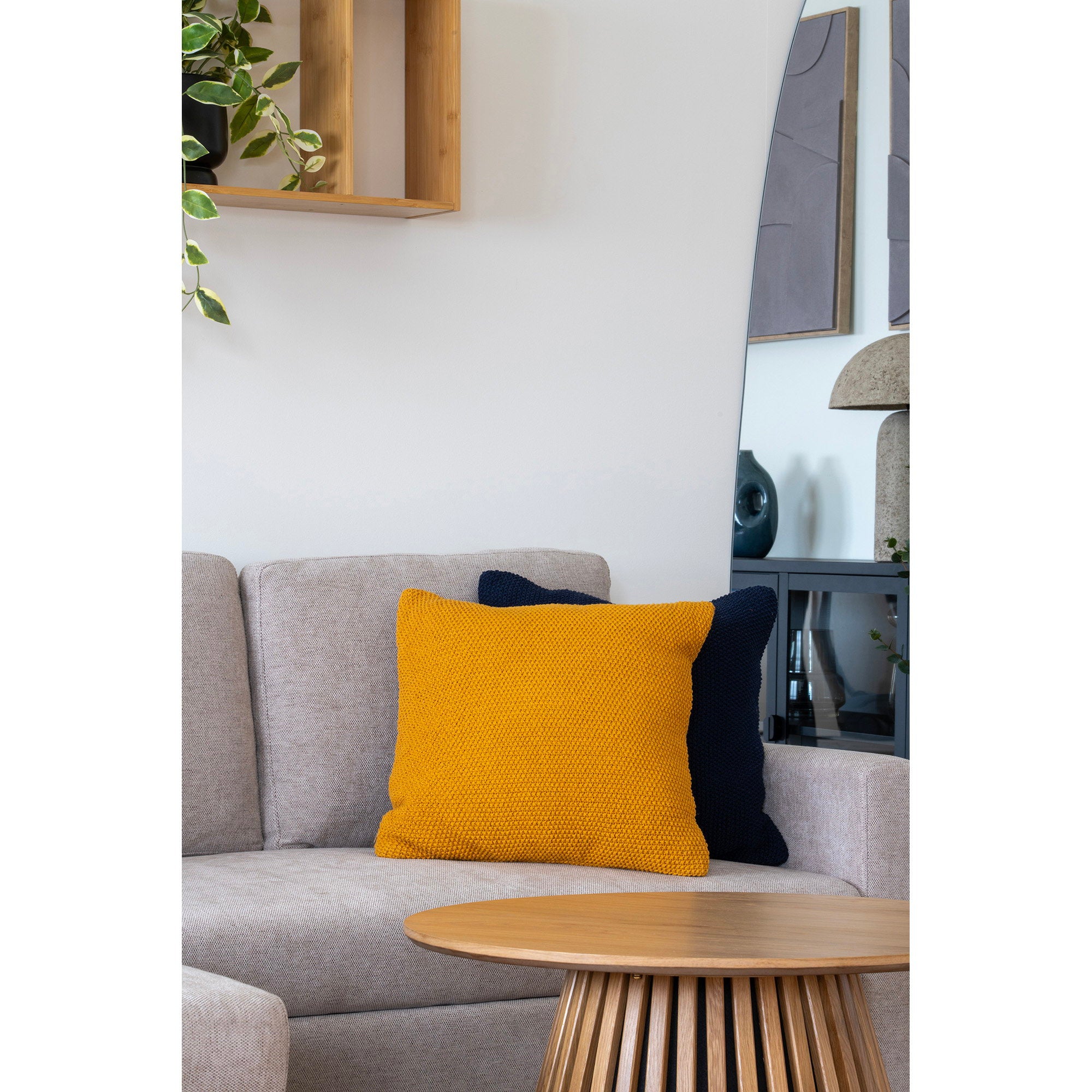 Coussin Santos ocre moutarde tricot posé sur canapé gris décor contemporain
