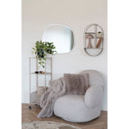 Coussin Galena fausse fourrure gris sur fauteuil bouclé gris clair ambiance cocooning