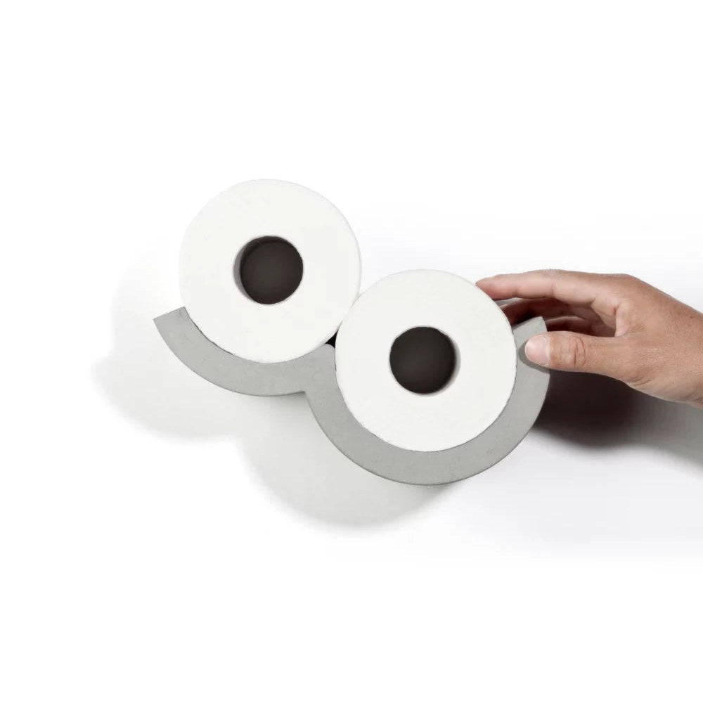 Main qui prend un rouleau de papier dans le dérouleur Cloud en béton fixé au mur