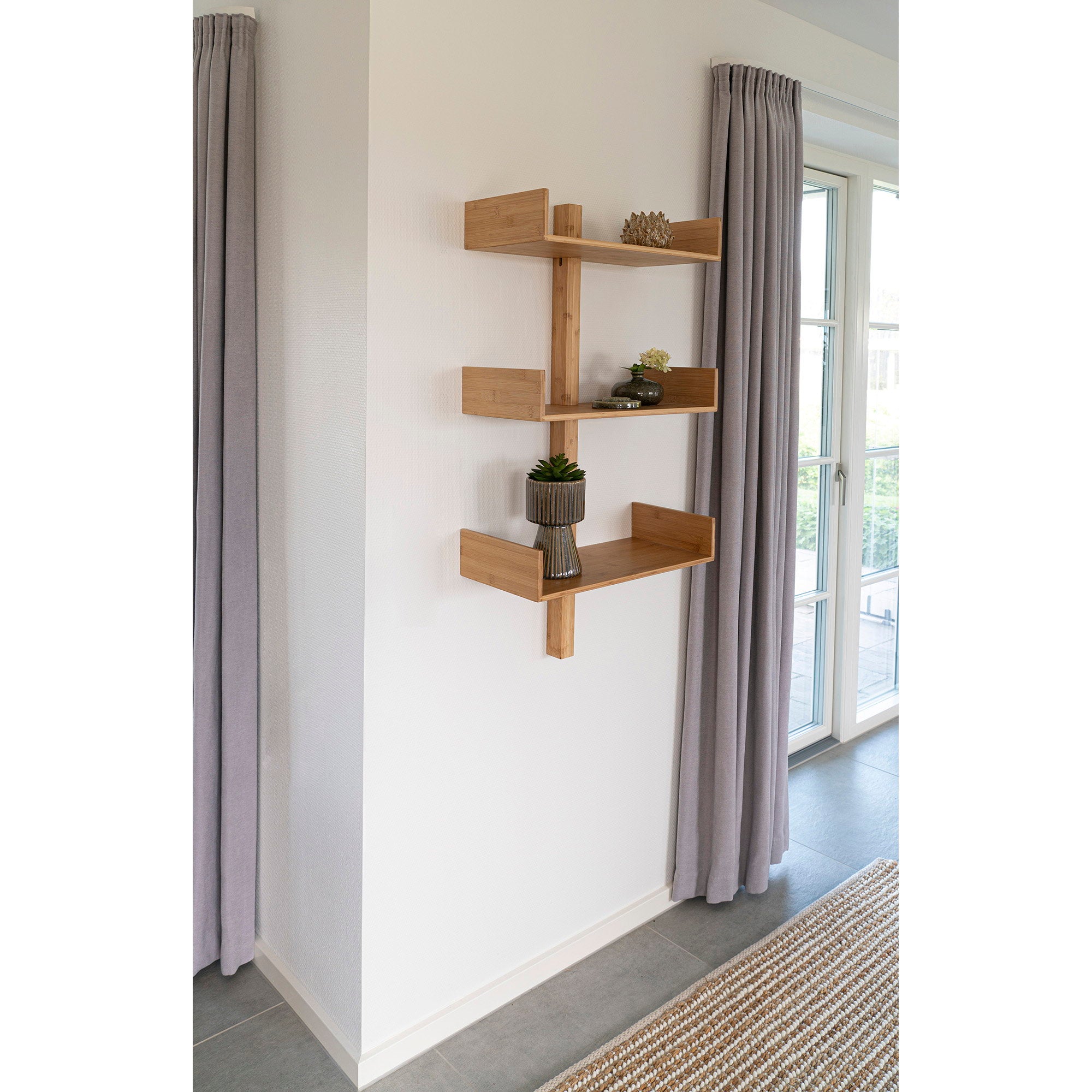 Étagère Villa bambou 3 tablettes en ambiance salon blanc entre rideaux gris objets déco