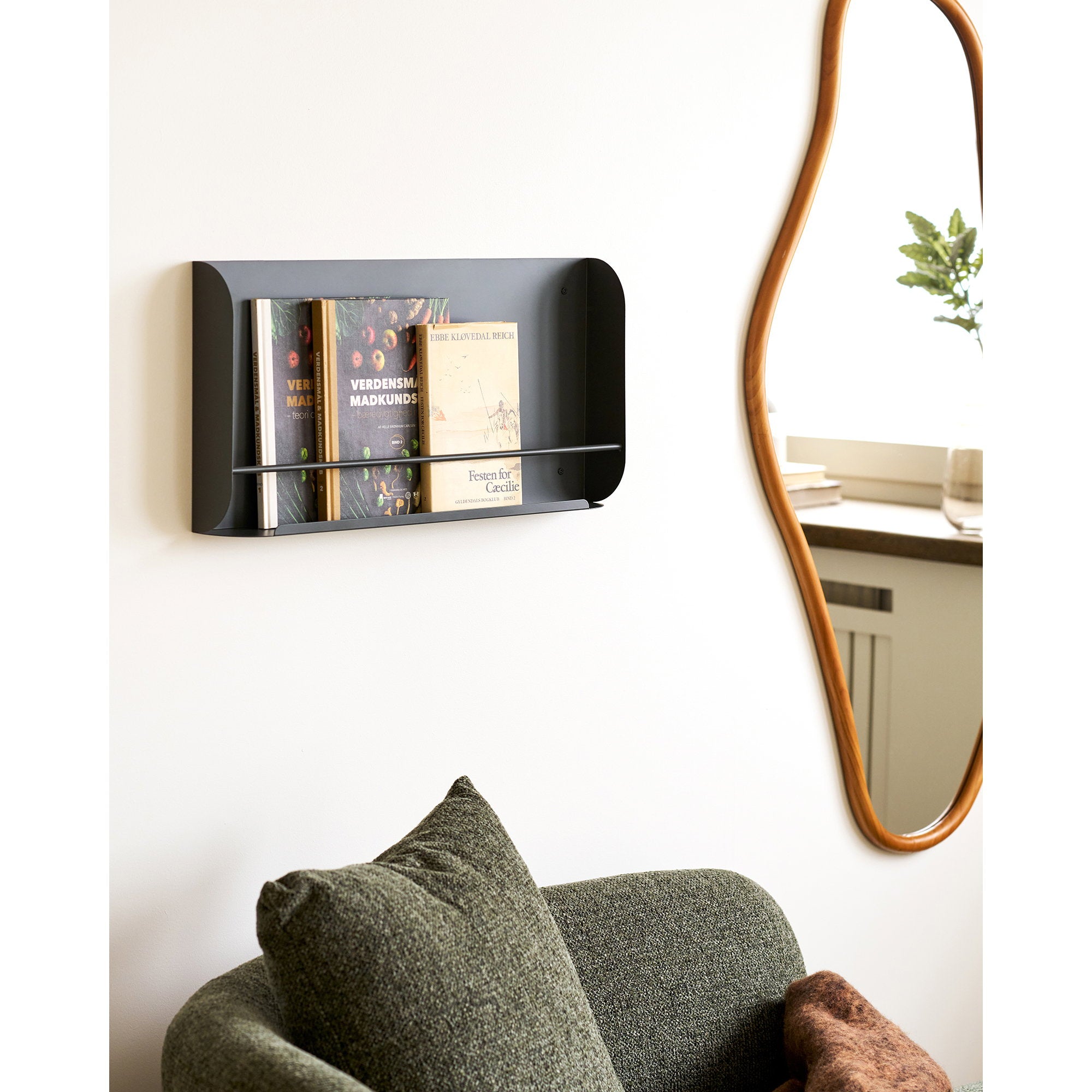 Étagère Volterra gris anthracite avec livres en ambiance salon au-dessus d'un canapé vert