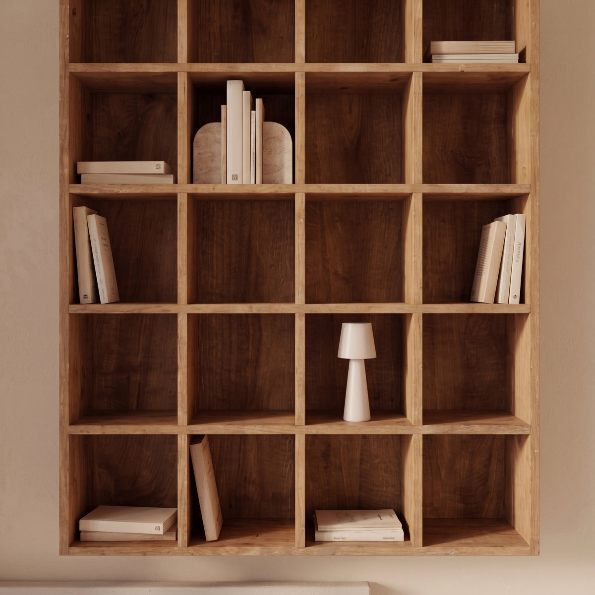 Cases de l'étagère Moss en pin naturel garnies de livres, de serre-livres et d'une petite lampe blanche