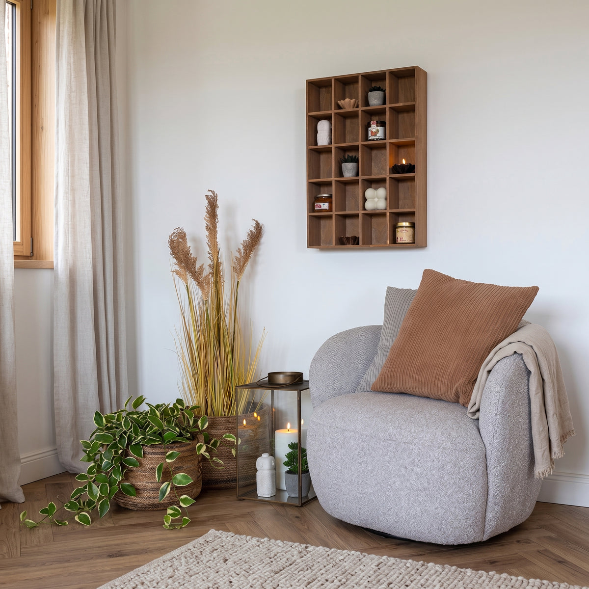 Étagère murale Moss en pin naturel garnie de bougies, de pots et de petites plantes au-dessus d'un fauteuil gris dans un salon
