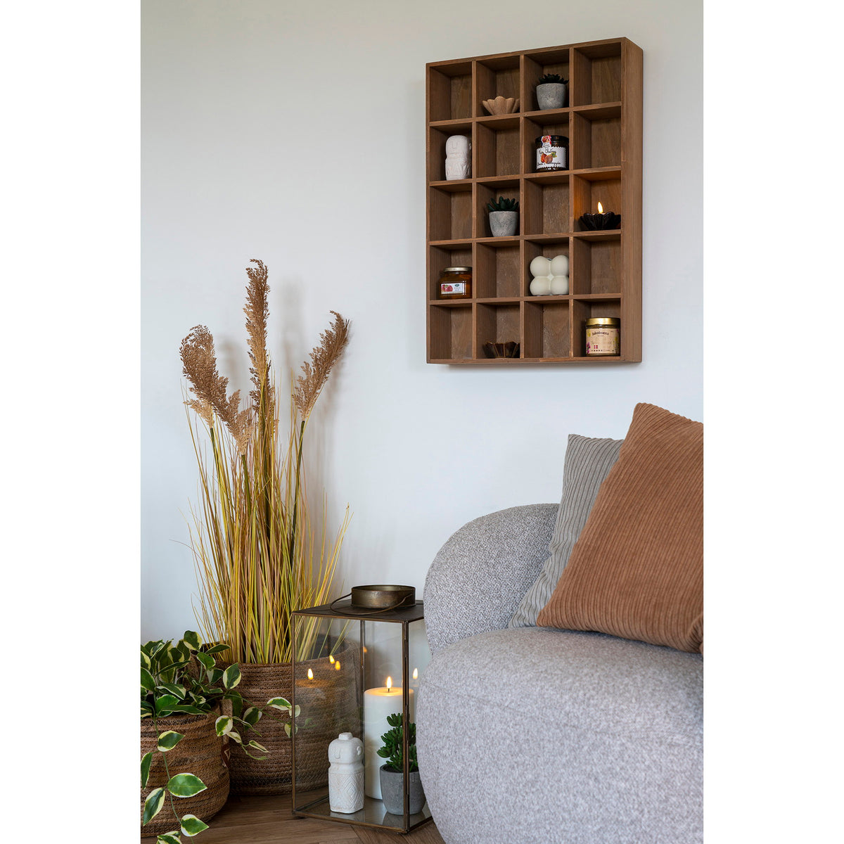 Étagère murale Moss en pin au mur d'un salon clair garnie de plantes grasses et de bocaux près d'une assise en bouclé gris