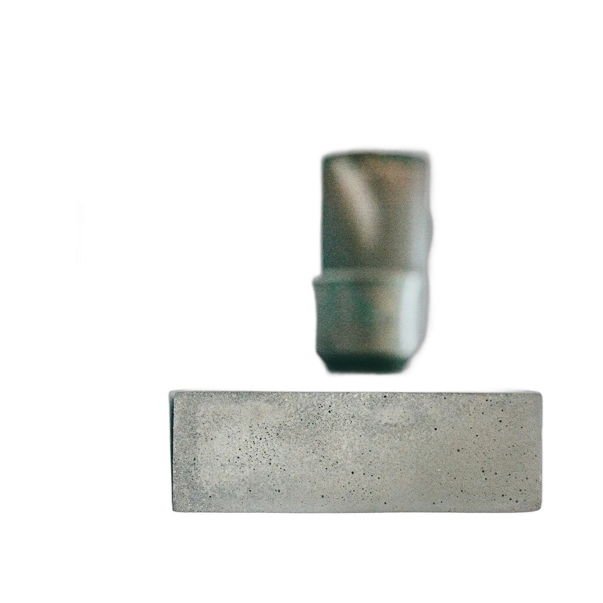 Tranche de l'étagère murale Sliced en béton sur fond blanc avec une tasse floue posée derrière