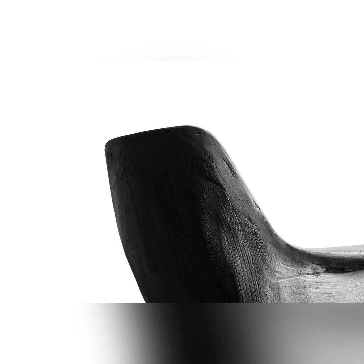 Gros plan sur le dos de la coque du fauteuil bas Hauteville et sa texture de béton brut