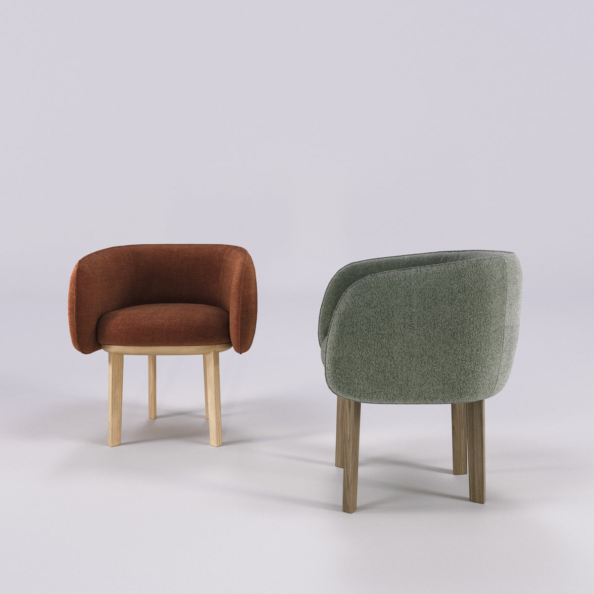 Fauteuils de table Nido en chêne et tissu rouille et en noyer et tissu vert sauge, côte à côte