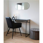 Fauteuil Harbo noir utilisé comme siège de bureau avec console noire et miroir ovale