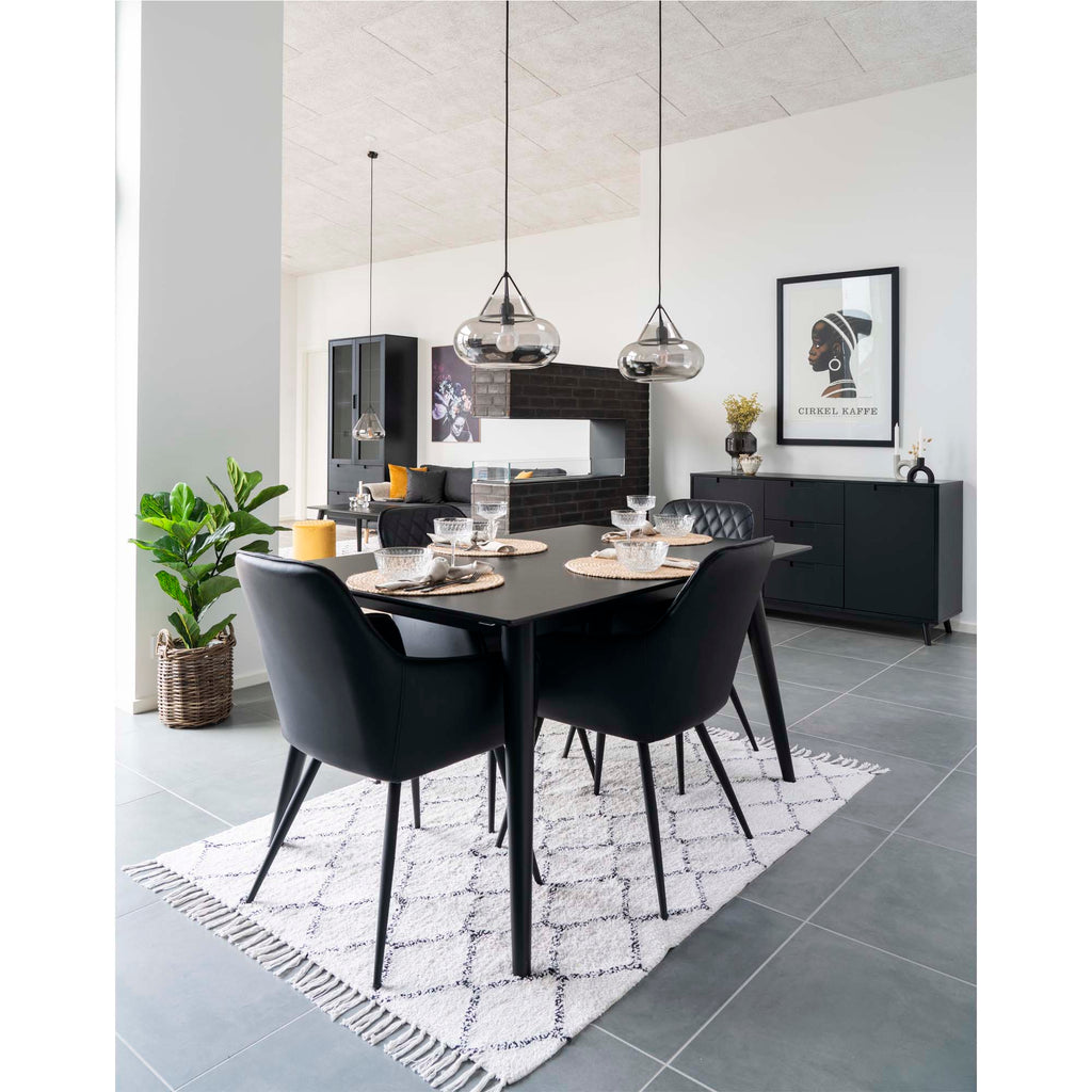Fauteuils Harbo noirs autour table noire dressée salle à manger design suspensions verre